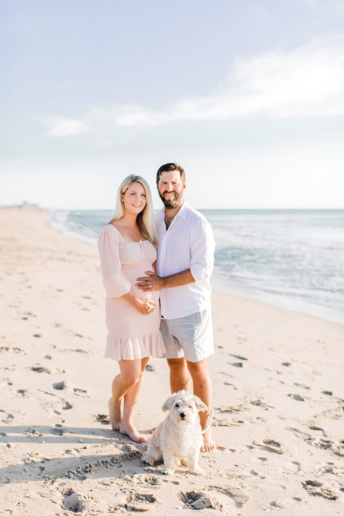 Beautiful beach portrait of couple and their puppy at sunset.