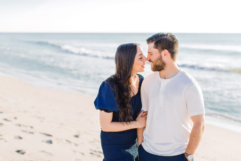 Romantic couple enjoying beach sunset, ocean backdrop, high-quality engagement photography.