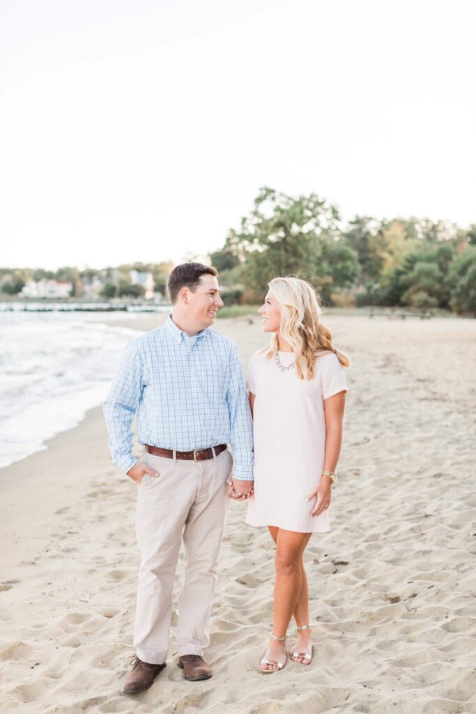 Beautiful engagement session on sandy beach with joyful couple smiling.