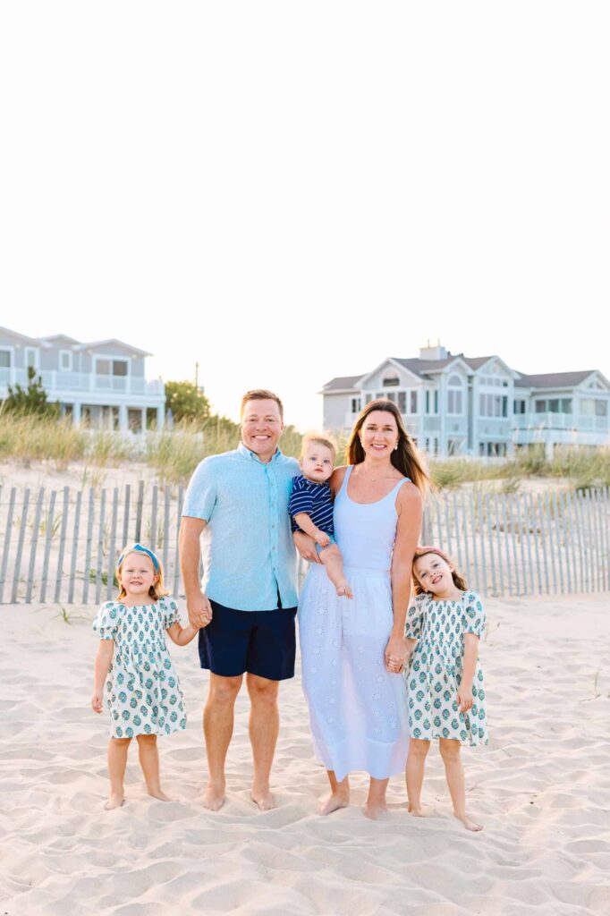 Happy family walking on beach with kids, capturing joyful moments in natural light.