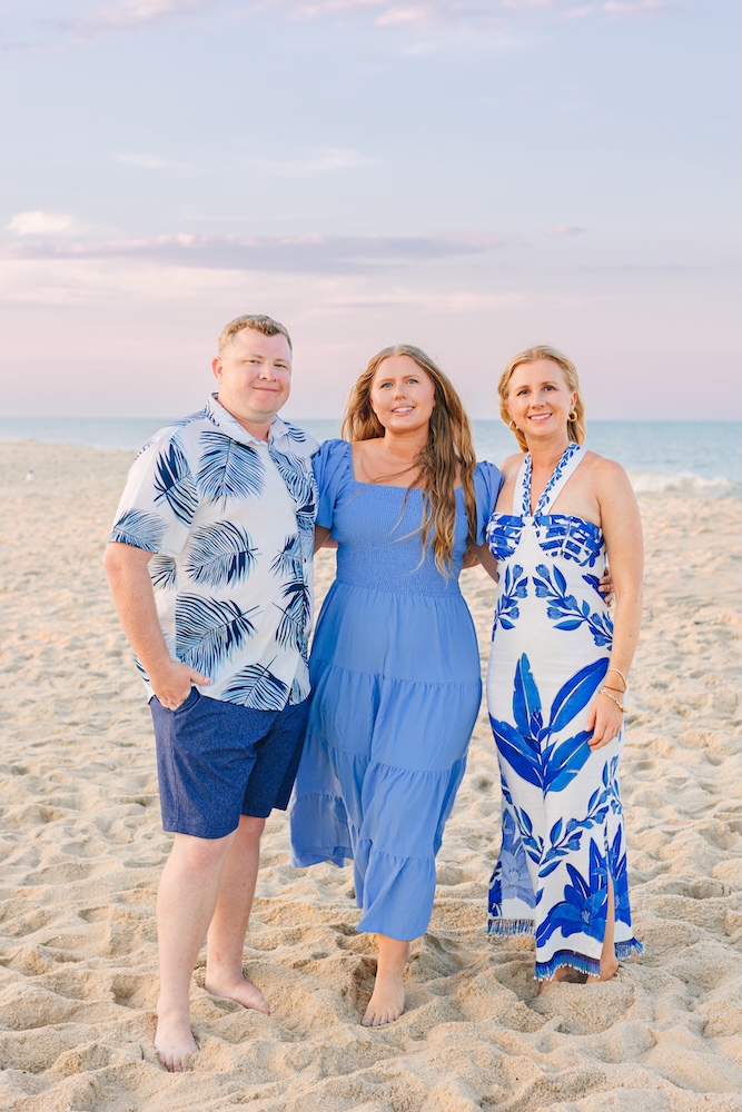 Family in coordinated blue and white outfits during golden hour beach session Fenwick Island DE