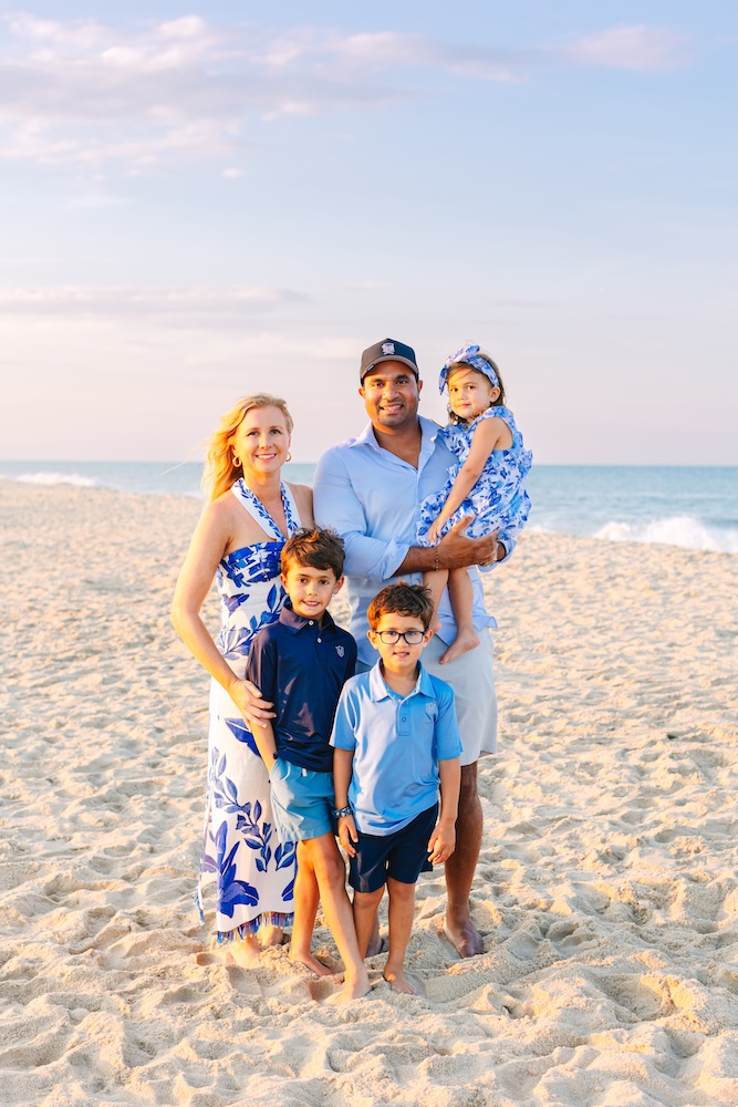 Family in coordinated blue and white outfits during golden hour beach session Fenwick Island DE